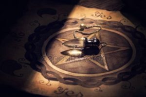 depositphotos_147829407-stock-photo-crystal-pendulum-on-a-board